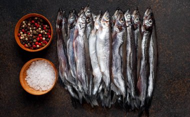 Koyu arkaplanda baharatları olan eritilmiş balıkların üst görünümü