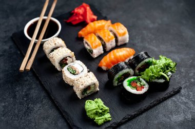 Yan görünüş, soya sosu ve yemek çubuklarıyla çeşitli suşi setlerinin yakın çekimi.