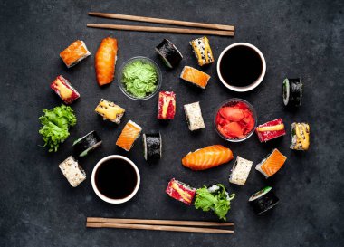 Çubuklu suşi seti, koyu arkaplanda soya sosu. 