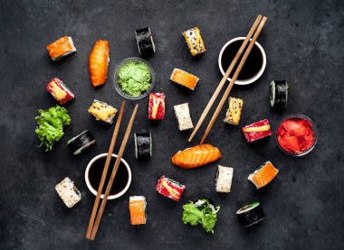 Çubuklu suşi seti, koyu arkaplanda soya sosu. 