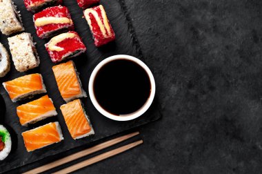 Farklı suşi dürümleri ve siyah arka planda nigiri suşisi.