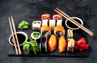 Soya sosu ve yemek çubuklarıyla hazırlanmış suşi setinin fotoğrafını kapat.