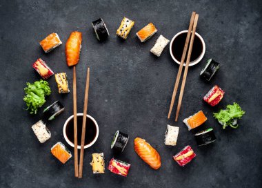 Çubuklu suşi seti, koyu arkaplanda soya sosu. 