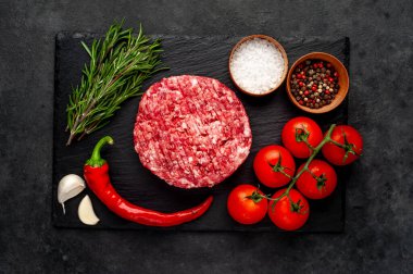 Biberiyeli çiğ hamburger köftesi ve arka planda baharatlar