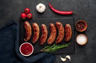 Bir taş zemin üzerinde baharatlı ızgara sosisler ve metin için kopyalama alanı.