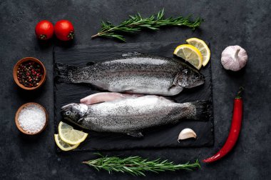 Taş zeminde baharat ve malzemelerle çiğ balık alabalığı.