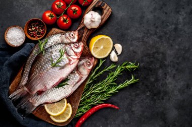 Limonlu ve kekikli Crucian sazan balığı taştan bir arka planda tahta üzerinde. Nehir balığı .