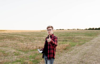 Tarlada gün batımında tabletli çiftçi, tarım yönetimi kavramı