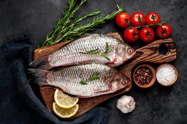 Limonlu ve kekikli Crucian sazan balığı taştan bir arka planda tahta üzerinde. Nehir balığı .