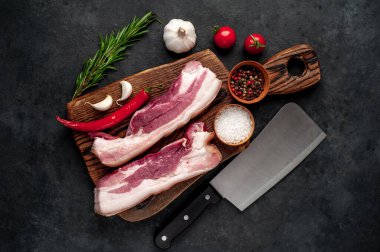 Metnin için fotokopi alanı olan taştan bir arka planda kesilmiş baharatlı çiğ domuz göğsü.