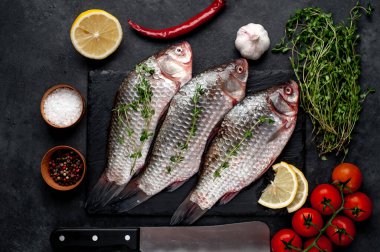 Limonlu ve kekikli Crucian sazan balığı taştan bir arka planda tahta üzerinde. Nehir balığı .