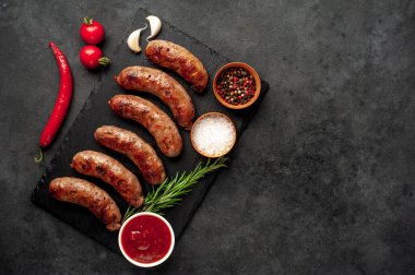 Bir taş zemin üzerinde baharatlı ızgara sosisler ve metin için kopyalama alanı.