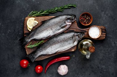 Taş zeminde baharat ve malzemelerle çiğ balık alabalığı.