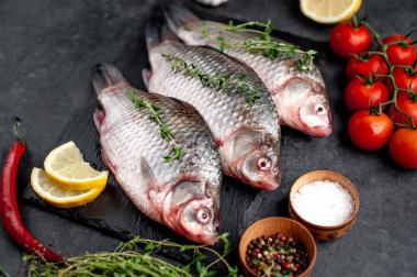 Limonlu ve kekikli Crucian sazan balığı taştan bir arka planda tahta üzerinde. Nehir balığı .