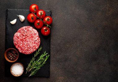 Biberiyeli çiğ hamburger köftesi ve arka planda baharatlar
