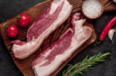 Metnin için fotokopi alanı olan taştan bir arka planda kesilmiş baharatlı çiğ domuz göğsü.