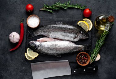 Taş zeminde baharat ve malzemelerle çiğ balık alabalığı.