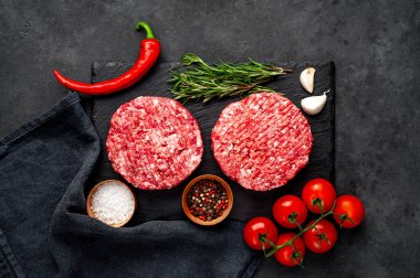 Biberiyeli hamburgerler ve arka planda baharatlar.