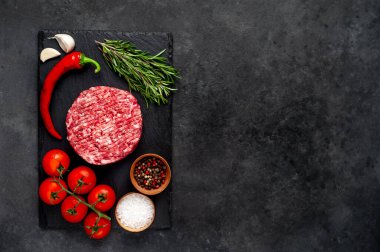 Biberiyeli çiğ hamburger köftesi ve arka planda baharatlar