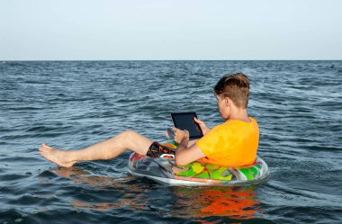 Suda şişme yüzük tabletli bir adam.