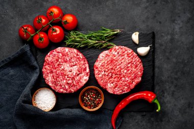 Biberiyeli hamburgerler ve arka planda baharatlar.