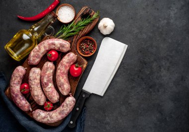 Metnin için kopyalama alanı olan taştan bir arka planda kesilmiş baharatlı çiğ sosisler.