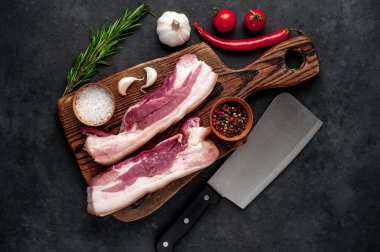 Metnin için fotokopi alanı olan taştan bir arka planda kesilmiş baharatlı çiğ domuz göğsü.