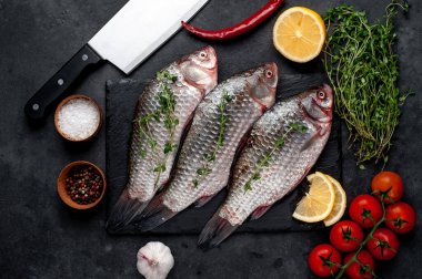 Limonlu ve kekikli Crucian sazan balığı taştan bir arka planda tahta üzerinde. Nehir balığı .