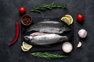 Taş zeminde baharat ve malzemelerle çiğ balık alabalığı.