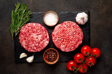Biberiyeli hamburgerler ve arka planda baharatlar.