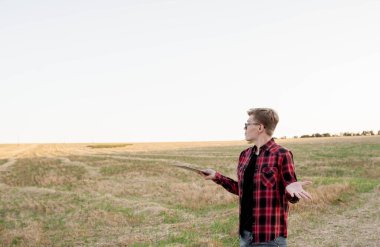 Tarlada gün batımında tabletli çiftçi, tarım yönetimi kavramı