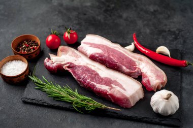 Metnin için fotokopi alanı olan taştan bir arka planda kesilmiş baharatlı çiğ domuz göğsü.