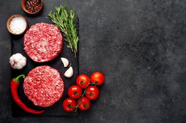 Biberiyeli hamburgerler ve arka planda baharatlar.