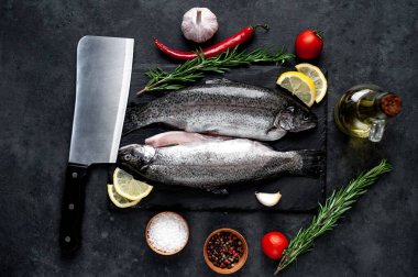 Taş zeminde baharat ve malzemelerle çiğ balık alabalığı.