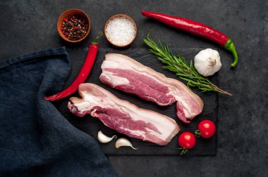 Metnin için fotokopi alanı olan taştan bir arka planda kesilmiş baharatlı çiğ domuz göğsü.