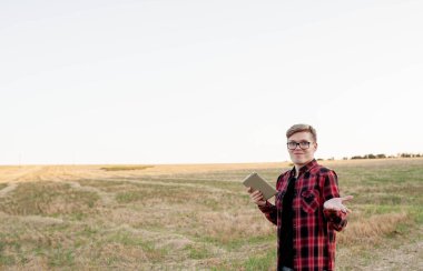 Tarlada gün batımında tabletli çiftçi, tarım yönetimi kavramı