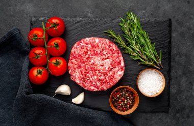 Biberiyeli çiğ hamburger köftesi ve arka planda baharatlar