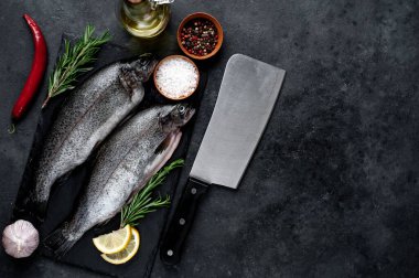 Taş zeminde baharat ve malzemelerle çiğ balık alabalığı.