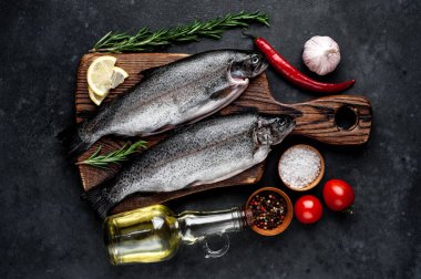 Taş zeminde baharat ve malzemelerle çiğ balık alabalığı.