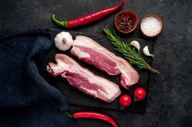 Metnin için fotokopi alanı olan taştan bir arka planda kesilmiş baharatlı çiğ domuz göğsü.