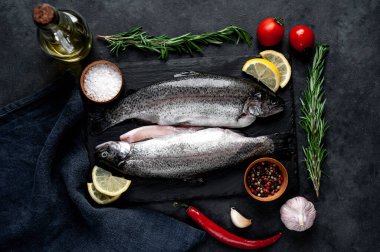 Taş zeminde baharat ve malzemelerle çiğ balık alabalığı.