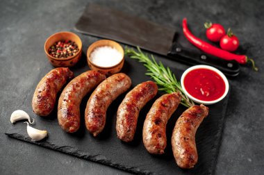 Bir taş zemin üzerinde baharatlı ızgara sosisler ve metin için kopyalama alanı.