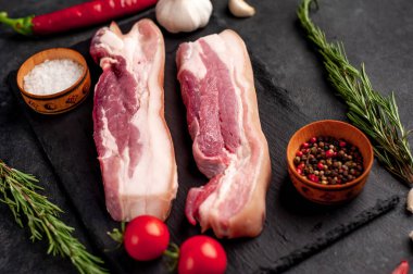 Metnin için fotokopi alanı olan taştan bir arka planda kesilmiş baharatlı çiğ domuz göğsü.