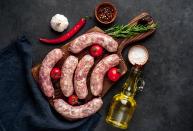 Metnin için kopyalama alanı olan taştan bir arka planda kesilmiş baharatlı çiğ sosisler.