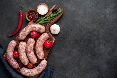Metnin için kopyalama alanı olan taştan bir arka planda kesilmiş baharatlı çiğ sosisler.