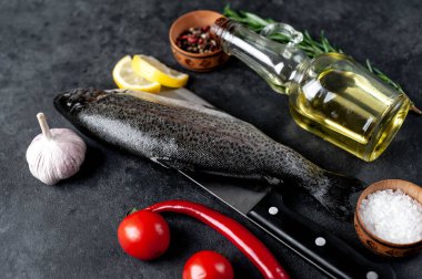 Taş zeminde baharat ve malzemelerle çiğ balık alabalığı.