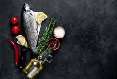 Taş zeminde baharat ve malzemelerle çiğ balık alabalığı.