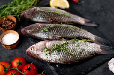 Limonlu ve kekikli Crucian sazan balığı taştan bir arka planda tahta üzerinde. Nehir balığı .