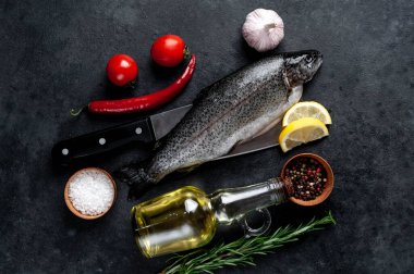 Taş zeminde baharat ve malzemelerle çiğ balık alabalığı.