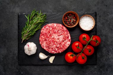Biberiyeli çiğ hamburger köftesi ve arka planda baharatlar